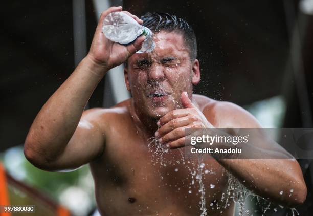 Wrestler cools off with water after competing on the first day of the 657th annual Kirkpinar Oil Wrestling Festival in Sarayici near Edirne, Turkey...