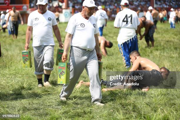 Groundstaff carry oil to the field on the first day of the 657th annual Kirkpinar Oil Wrestling Festival in Sarayici near Edirne, Turkey on July 13,...