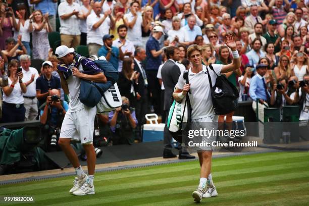 John Isner of The United States and Kevin Anderson of South Africa leave Centre Court after their Men's Singles semi-final match on day eleven of the...