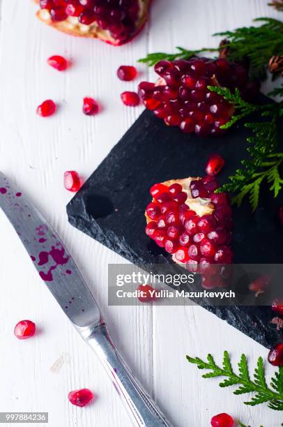 half pomegranate and seeds a branch of spruce - spruce branch stock pictures, royalty-free photos & images