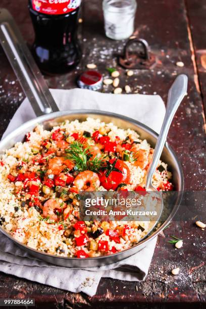 couscous with fried prawns, mixed vegetables, pine nuts served in a cooking pan on a wooden table, selective focus. traditional eastern meal. summer picnic food. - roasted pepper stock pictures, royalty-free photos & images