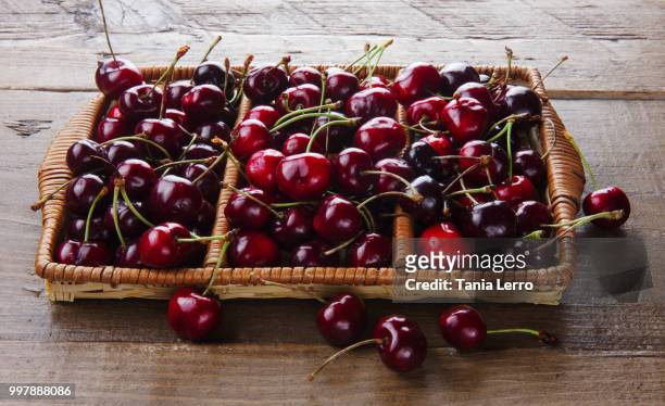 wooden basket full of fresh delicious red cherries - red delicious stockfoto's en -beelden