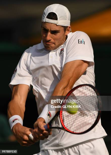 Player John Isner returns against South Africa's Kevin Anderson during the final set tie-break of their men's singles semi-final match on the...