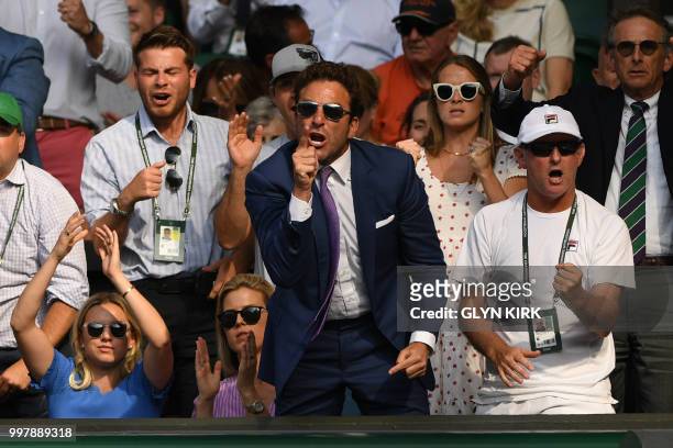 Former tennis player Justin Gimelstrob reacts as he sits in the familly box whilst watching US player John Isner play against South Africa's Kevin...
