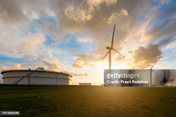 oil storage tank windmill in oil refinery industry in morning at - wind energy storage stock pictures, royalty-free photos & images