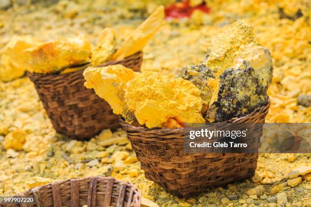 baskets full of sulfur ore at mount ijen crater lake, indonesia - gift baskets stock-fotos und bilder