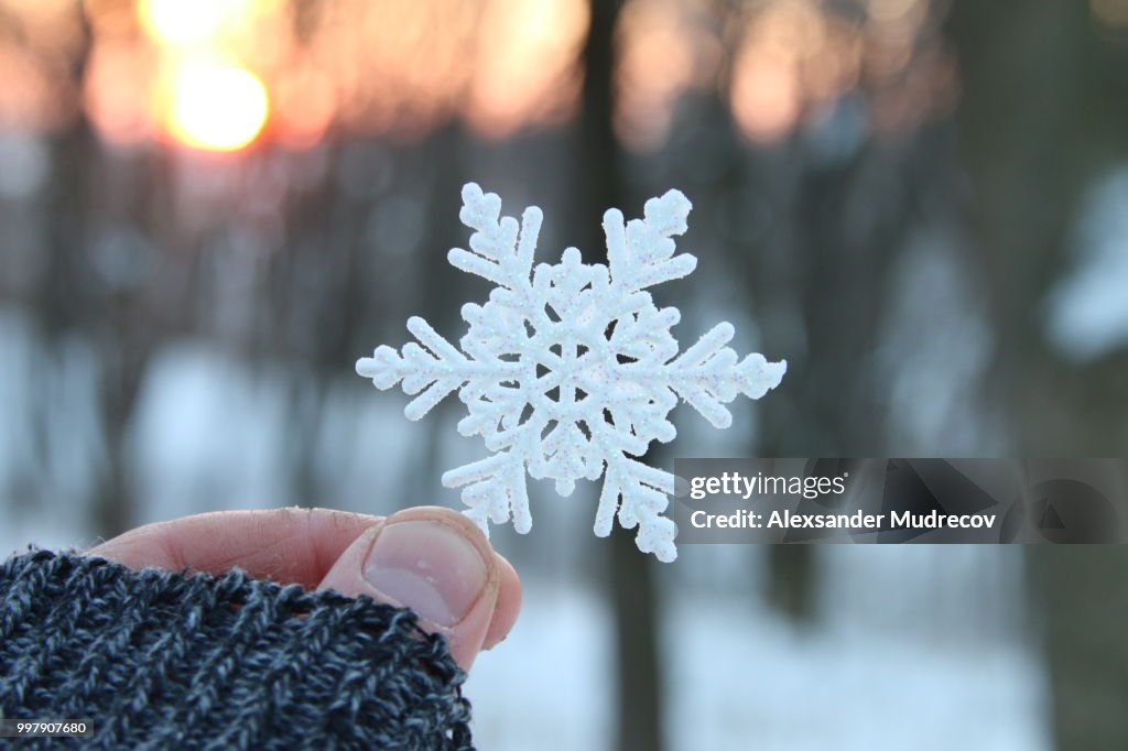 Cold or frost idea, hand holding a snowflake