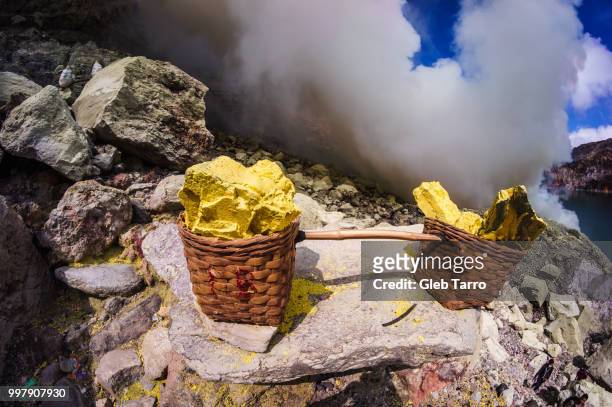 baskets full of sulfur ore at mount ijen crater lake, indonesia - east java province stock pictures, royalty-free photos & images