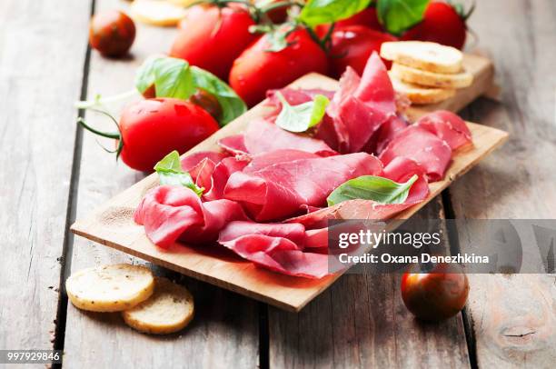 appetizer with italian bresaola and tomato - bresaola stock-fotos und bilder