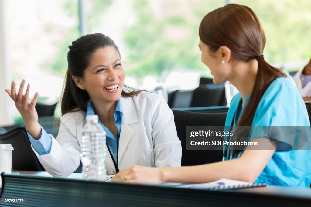 Female doctor talks with colleague at medical seminar
