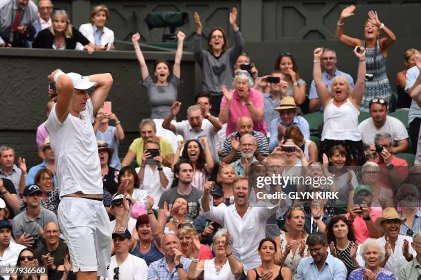 Spectators cheers as South Africa's Kevin Anderson reacts after winning against US player John Isner during the final set tie-break of their men's...