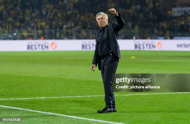 Bayern's head coach Carlo Ancelotti stands in front of the fans and celebrates the victory after the ending of the DFL-Supercup match between...