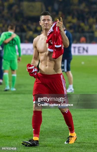 Bayern's Robert Lewandowski points to his fans while holding his shirt in his hands after the ending of the DFL-Supercup match between Borussia...