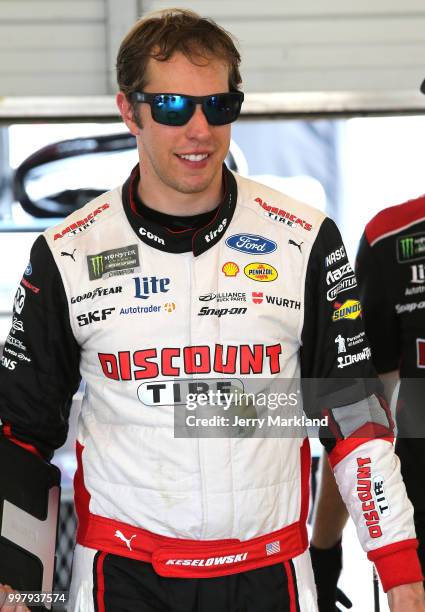 Brad Keselowski, driver of the Discount Tire Ford, stands in the garage area during practice for the Monster Energy NASCAR Cup Series Quaker State...