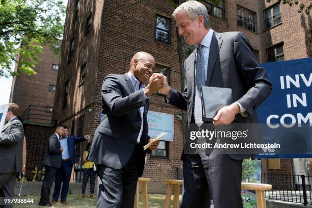 Public housing residents watch New York City mayor Bill DeBlasio and Brooklyn borough president Eric Adams speak at a ceremony for the groundbreaking...