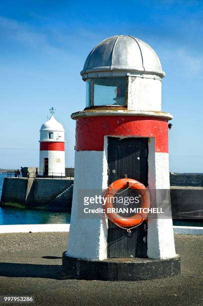 two small red and white navigation towers at the entrance to a harbour - red beacon stock pictures, royalty-free photos & images