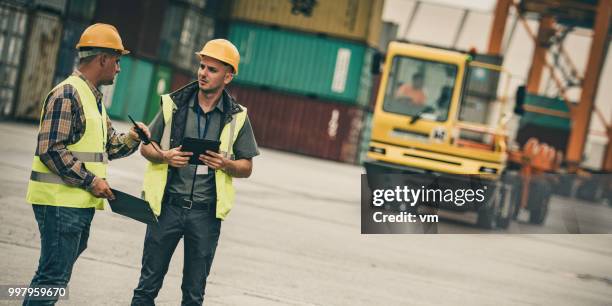 foreman talking to dock worker - foreman stock pictures, royalty-free photos & images