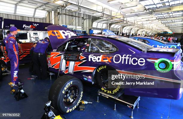 Denny Hamlin, driver of the FedEx Office Toyota, stands in the garage area during practice for the Monster Energy NASCAR Cup Series Quaker State 400...