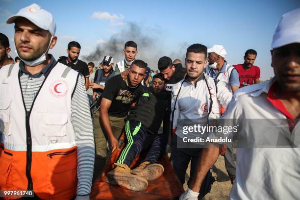 Medics carry a wounded Palestinian after Israeli security forces' intervention during the "Great March of Return" demonstration with ''Fidelity to...