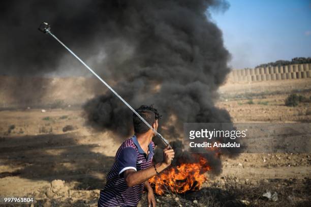 Palestinian uses slingshot during the "Great March of Return" demonstration with ''Fidelity to Khan Al-Ahmar'' near Israel-Gaza border at Al-Bureyc...