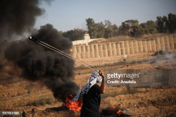 Palestinian uses slingshot during the "Great March of Return" demonstration with ''Fidelity to Khan Al-Ahmar'' near Israel-Gaza border at Al-Bureyc...