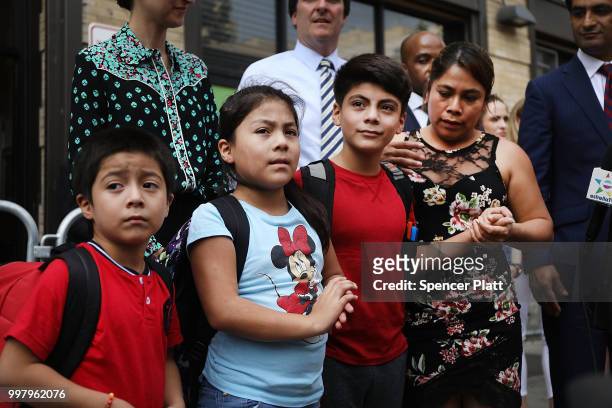 Yeni Maricela Gonzalez Garcia stands with her children 6 year-old Deyuin, 9 year-old Jamelin and 11 year-old Lester as she and her lawyer speak with...