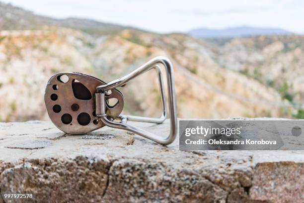 steel pulley on the edge of the cliff above a zip-lining course in the desert near cabo san lucas. - cabo stock pictures, royalty-free photos & images