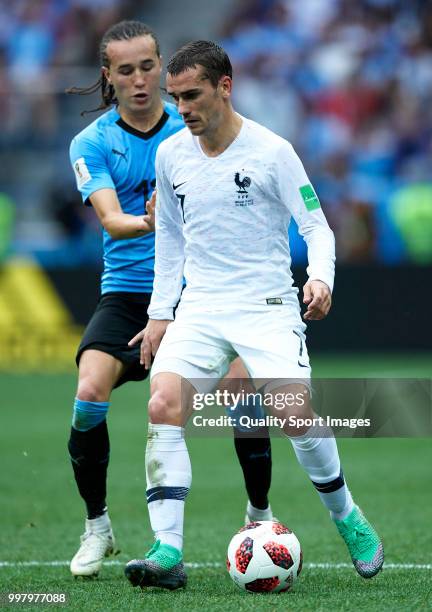 Diego Laxalt of Uruguay competes for the ball with Antoine Griezmann of France during the 2018 FIFA World Cup Russia Quarter Final match between...