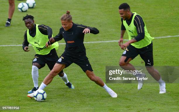 Dwight Gayle controls the ball whilst being challenged by Christian Atsu and Jamaal Lascelles during the Newcastle United Training session at Carton...