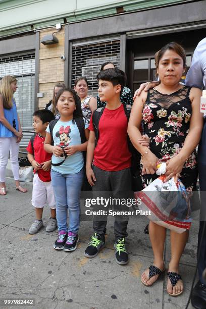 Yeni Maricela Gonzalez Garcia stands with her children 6 year-old Deyuin, 9 year-old Jamelin and 11 year-old Lester as she and her lawyer speak with...