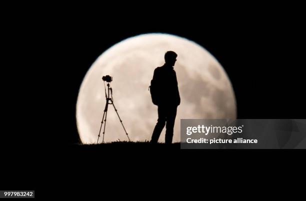 Man photographs the partial moon eclipse in Munich, Germany, 07 August 2017. The sun, earth and moon are almost exactly aligned in a partial moon...