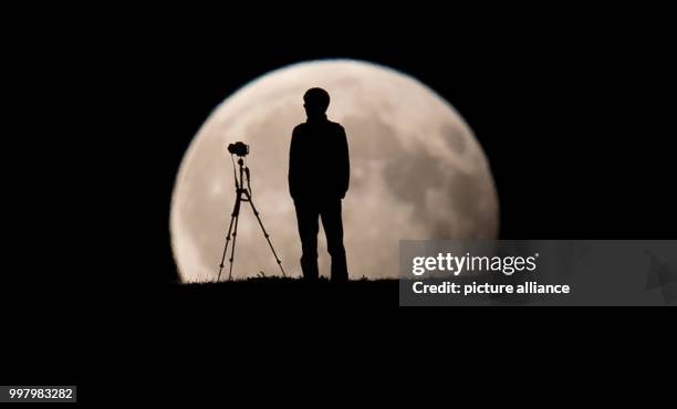 Man photographs the partial moon eclipse in Munich, Germany, 07 August 2017. The sun, earth and moon are almost exactly aligned in a partial moon...