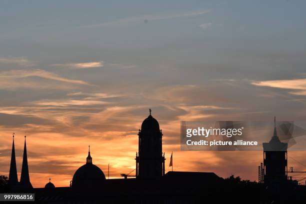 The sun sets over the Red City Hall , the Old City House, the Cathedral and the towers of St. Nicholas' Church in central Berlin, Germany, 7 August...
