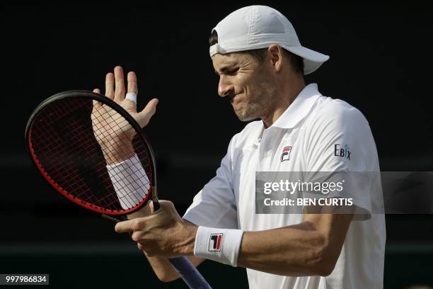 Player John Isner reacts against South Africa's Kevin Anderson during the final set tie-break of their men's singles semi-final match on the eleventh...