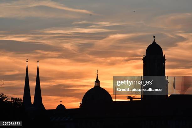 The sun sets over the Red City Hall , the Old City House, the Cathedral and the towers of St. Nicholas' Church in central Berlin, Germany, 7 August...