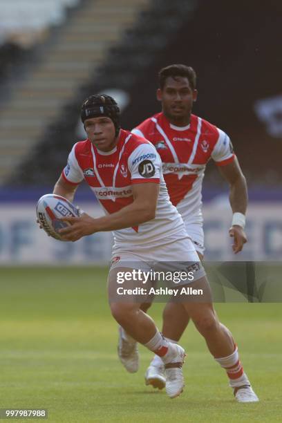 Jonny Lomax of St Helens runs with the ball as teammate Ben Barba looks on during the BetFred Super League match between Hull FC and St Helens Saints...