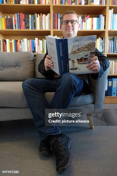 Ebbe Volquardsen, junior professor in cultural history at the University of Nuuk, with a book in his office in Nuuk, Greenland, 3 May 2017. Around 50...