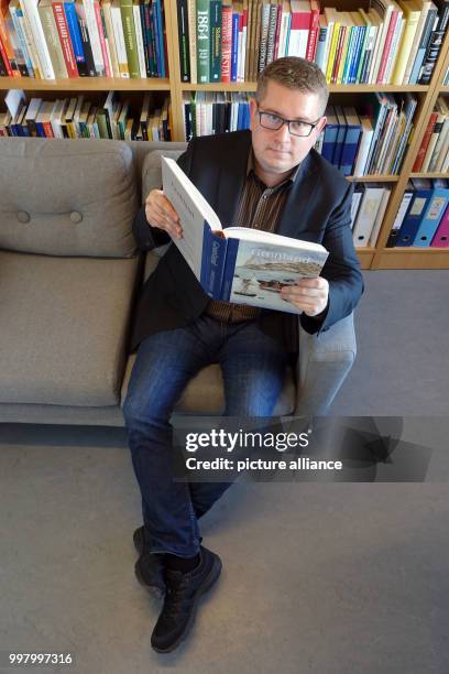 Ebbe Volquardsen, junior professor in cultural history at the University of Nuuk, with a book in his office in Nuuk, Greenland, 3 May 2017. Around 50...