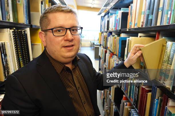 Ebbe Volquardsen, junior professor in cultural history at the University of Nuuk, with a book in the university's library in Nuuk, Greenland, 3 May...