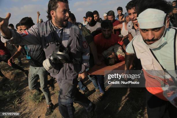 Paramedics and protesters carry the body of 15-year-old killed Palestinian protester Othman Rami Halles away from clashes with Israeli forces during...