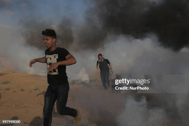 Picture taken on July 13, 2018 shows tear gas canisters fired by Israeli forces landing amidst protesters during a demonstration along the border...