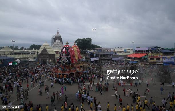 Devotees and police personnel pull the wooden chariots to set it in front of the Shree Jagannath temple on the eve of temple ditties annual chariot...