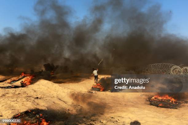 Palestinian demonstrators set tyres on fire as they take part in the "Great March of Return" demonstration with ''Fidelity to Khan Al-Ahmar'' near...