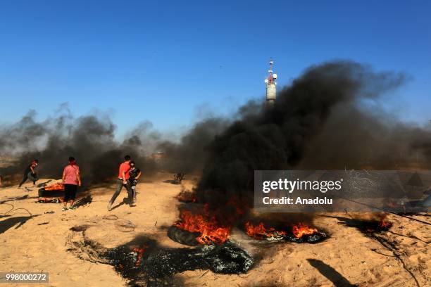 Palestinian demonstrators set tyres on fire as they take part in the "Great March of Return" demonstration with ''Fidelity to Khan Al-Ahmar'' near...