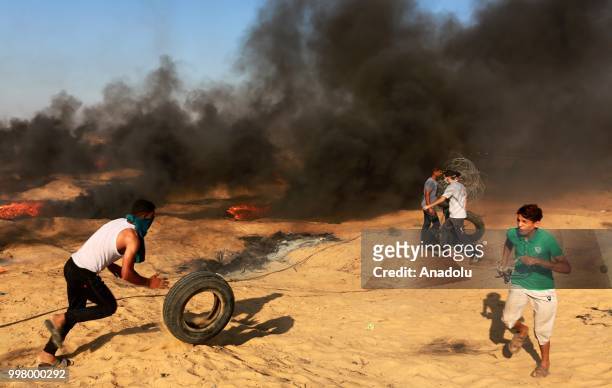 Palestinian demonstrators set tyres on fire as they take part in the "Great March of Return" demonstration with ''Fidelity to Khan Al-Ahmar'' near...