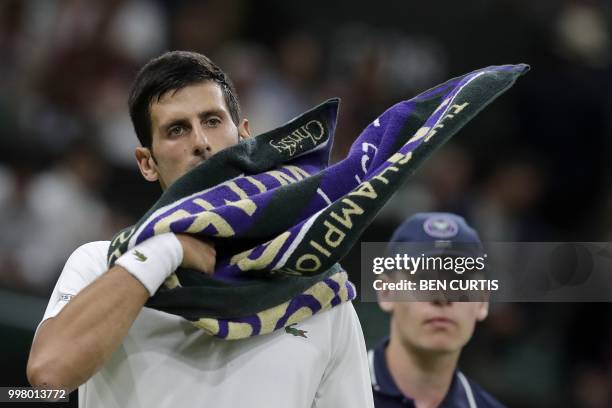 Serbia's Novak Djokovic uses a towel during a break in play against Spain's Rafael Nadal during their men's singles semi-final match on the eleventh...