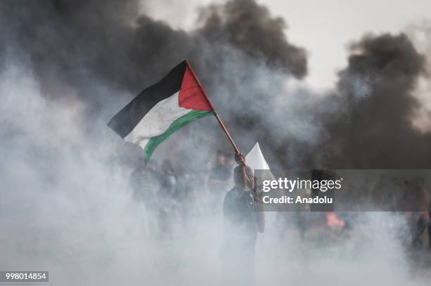 Israeli forces use tear gas to disperse Palestinian demonstrators taking part in the "Great March of Return" demonstration with ''Fidelity to Khan...
