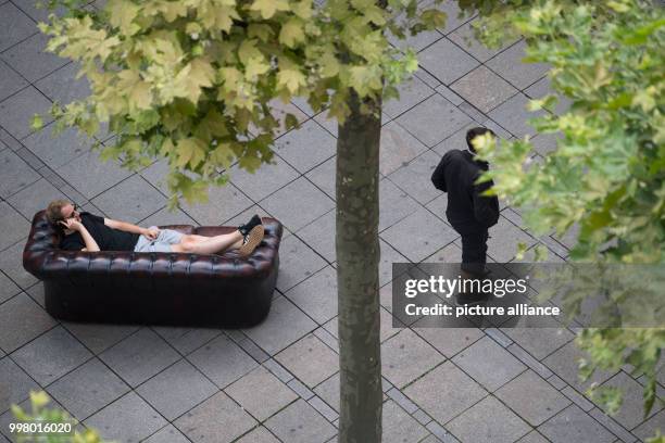 The German rapper known as Weekend makes a phone call while lying on a sofa during filming for a music video in Stuttgart, Germany, 9 August 2017....