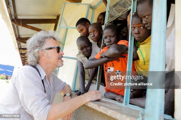 German musician Wolfgang Niedecken with children in the Rhino Camp, a refugee camp for displaced children from South Sudan, in Ofua, Uganda, 9 August...