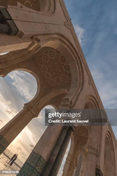 two lovers under an arch of mosque hassan ii, casablanca, morocco - laurent sauvel stock pictures, royalty-free photos & images